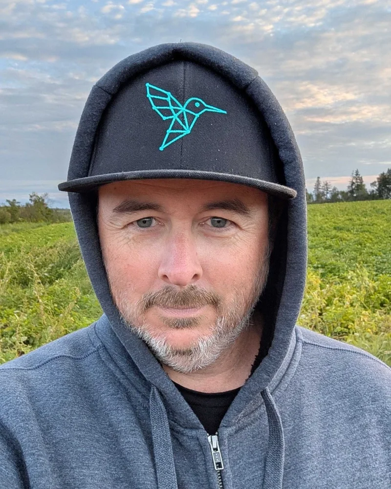 Kyle Bassett in an agronome.ai cap and hoodie in a potato field
